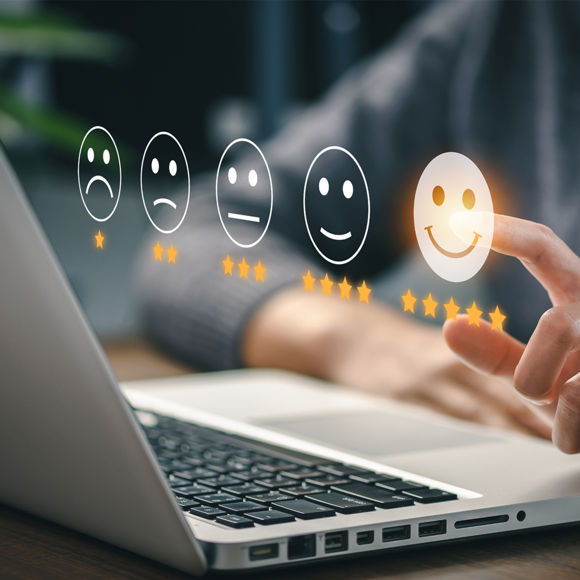 Kunde bewertet Dienstleistung mit Smiley auf Laptop