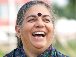 Ein Porträt von Vandana Shiva, bei dem sie herzhaft lacht.