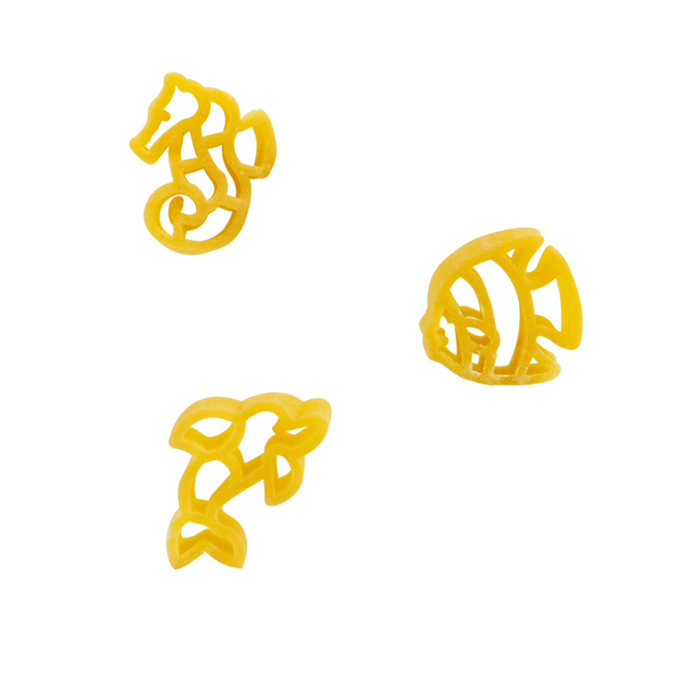 Three yellow pasta pieces shaped like sea creatures
