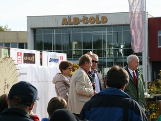 Menschen stehen vor dem Eingang eines Aldi-Süd-Marktes mit Glasfassade und sichtbarem Logo