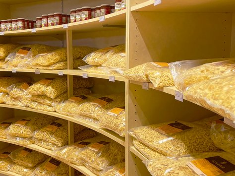 Regale mit großen durchsichtigen Plastikbeuteln voller verschiedener Nudelsorten