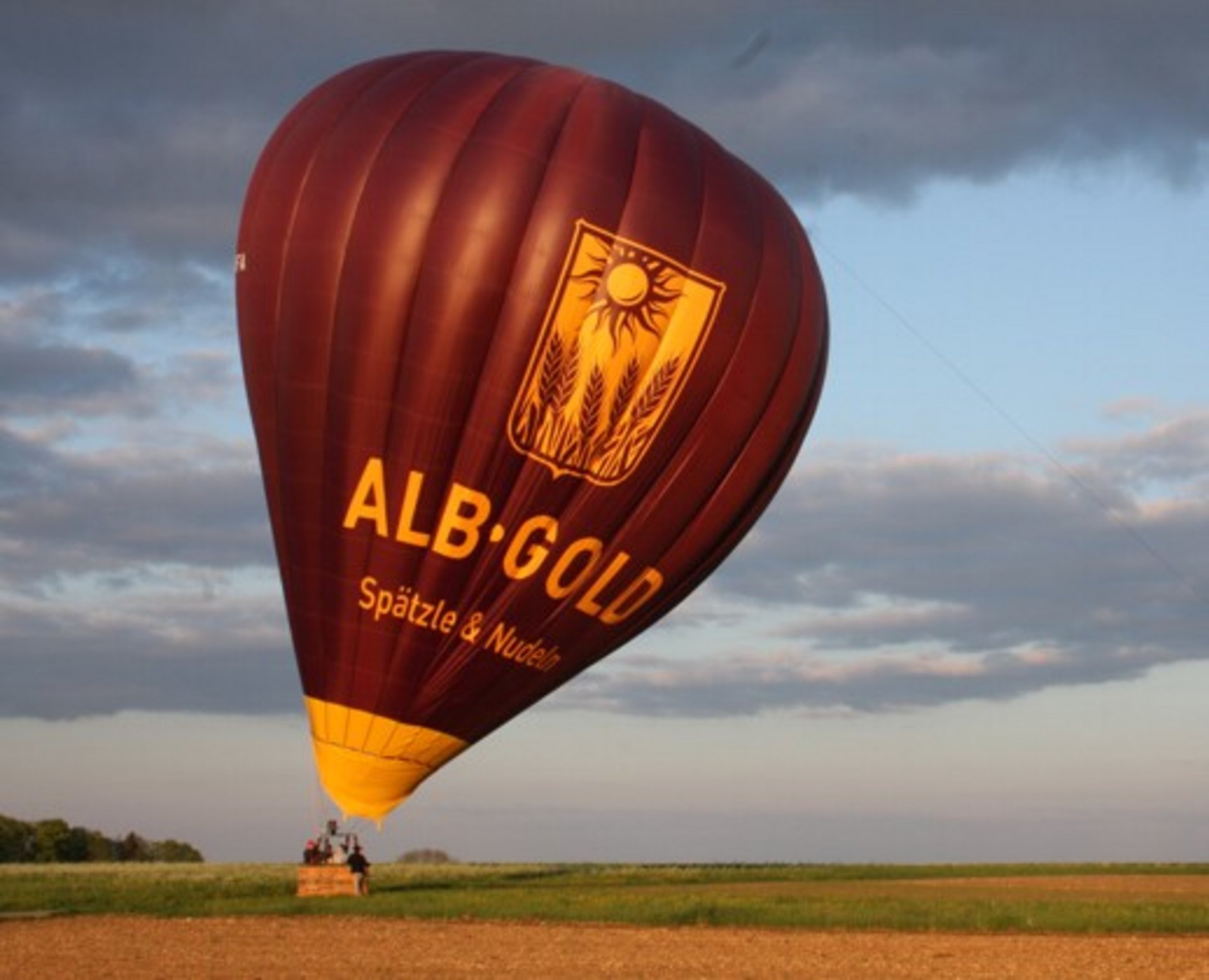 Der ALB-GOLD Ballon bei der Landung auf einem Feld.