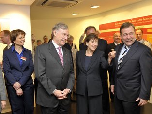 Horst Köhler in einer Gruppe von Menschen lächelnd.