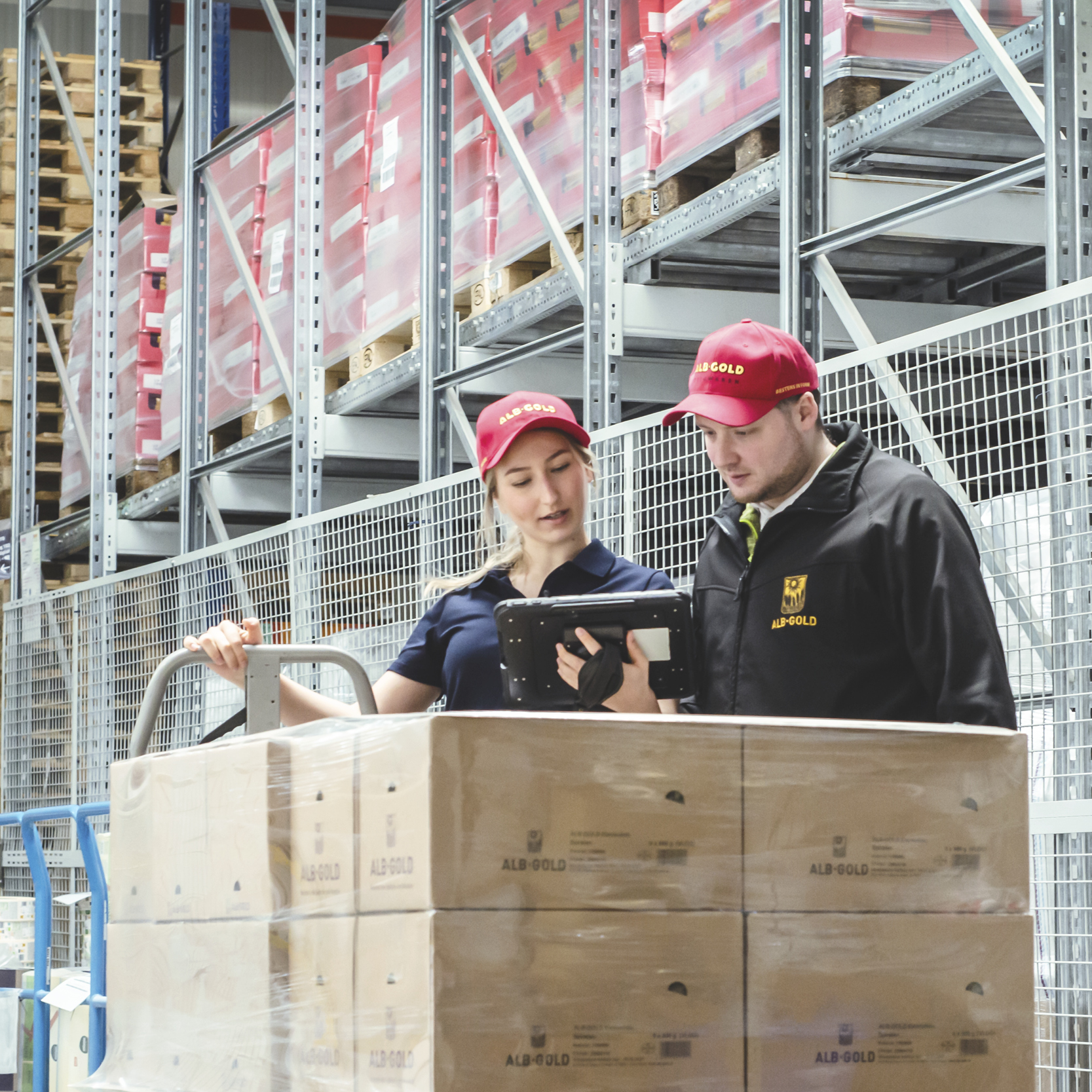 Zwei Lagerarbeiter besprechen den Transport von Waren in einem Lager.